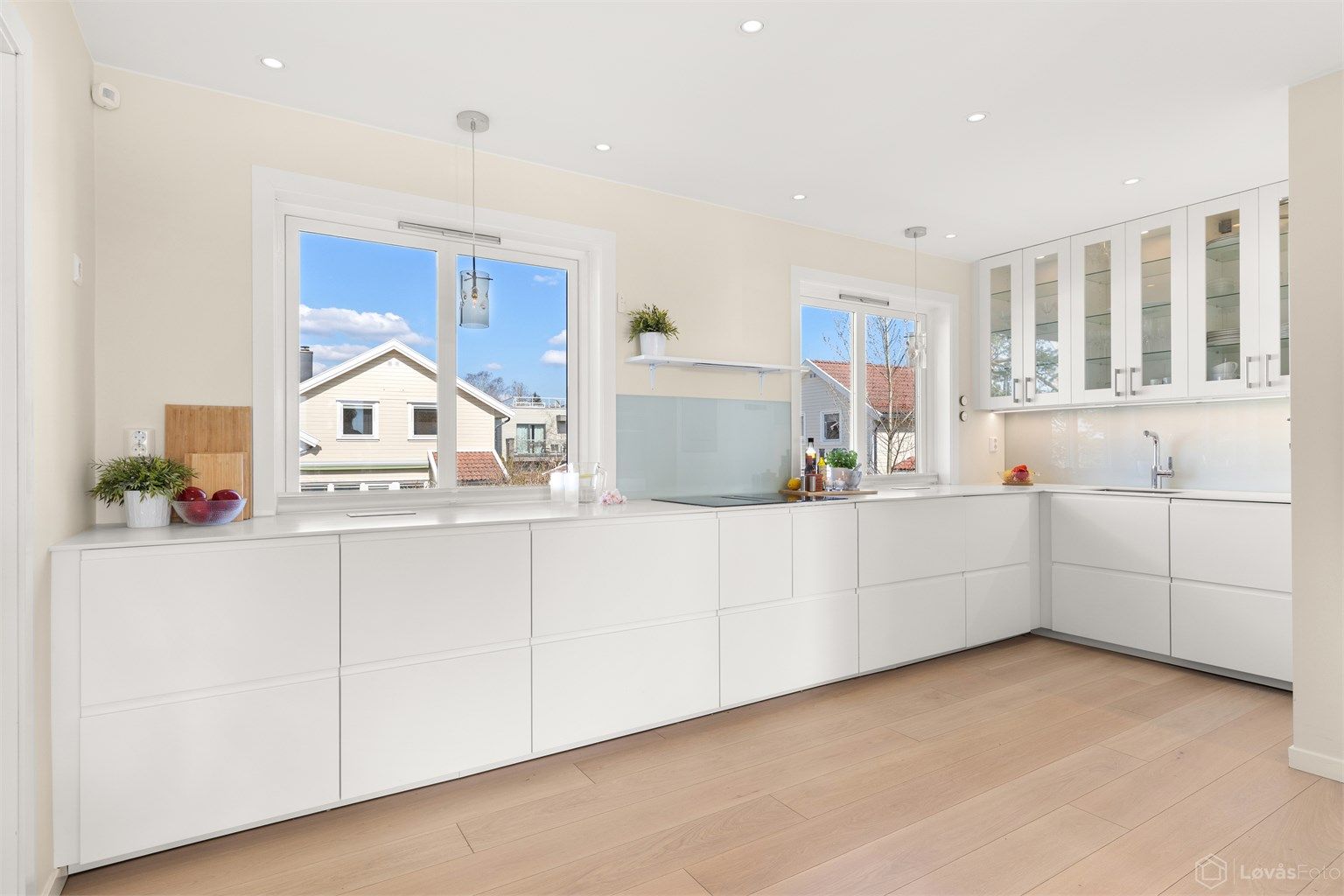 Kjøkkenet fremstår som en velutstyrt, funksjonell og innbydende arbeidsplass, i direkte tilknytning til stue og spisestue. Store vindusflater sørger for rikelig med naturlig lys. Innredningen har glatte fronter og en solid benkeplate i kompositt.