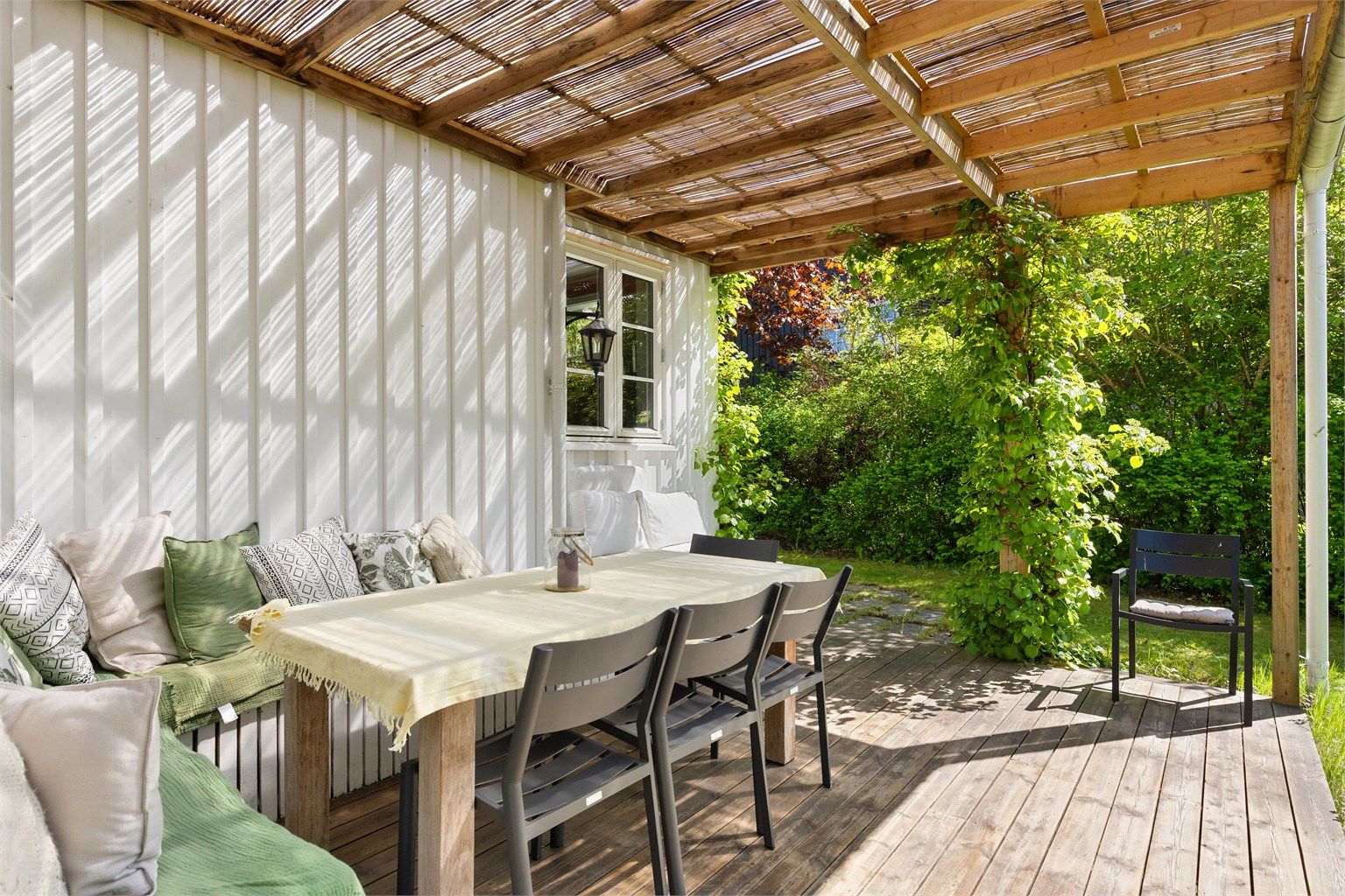 Uteplassen har plassbygde sittebenker og plass til et spisebord en grill