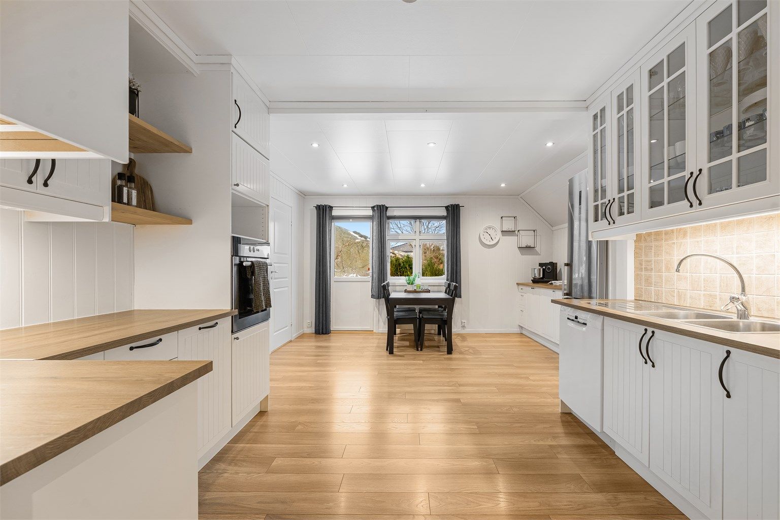 Stort kjøkken med mye oppbevaring og benkplass.