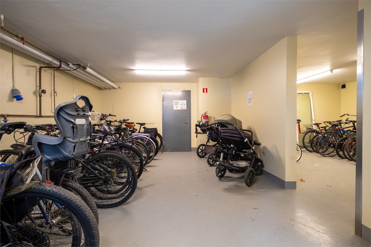 Romslig fellesbod i byggets kjeller med nyetablert sykkel- og barnevognparkering.