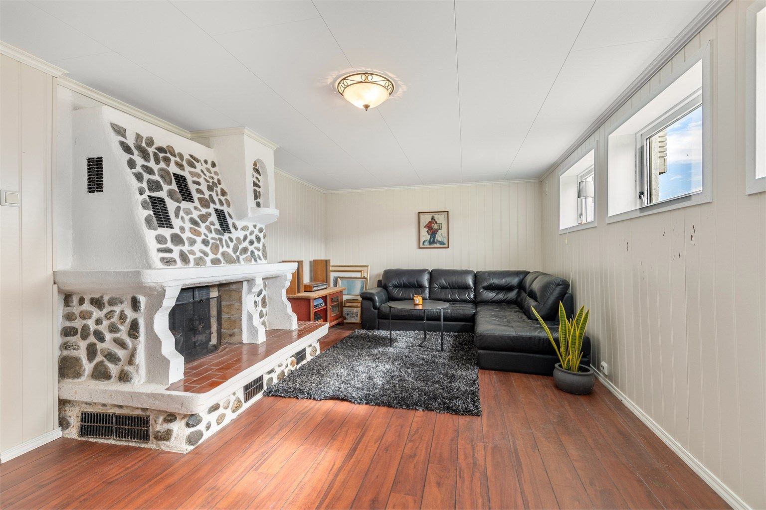 I underetasjen finner du en romslig kjellerstue med en karakteristisk vedpeis fra byggeåret - ikke byggemeldt og godkjent