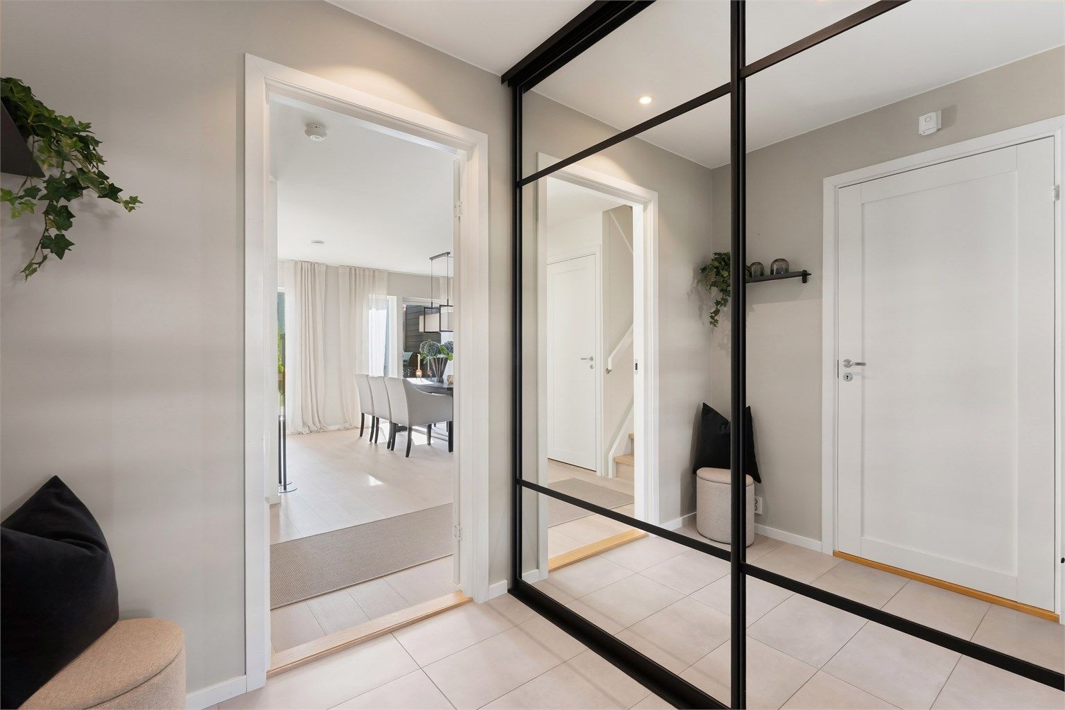 Romslig skyvedørsgarderobe med speilfronter i entréen.