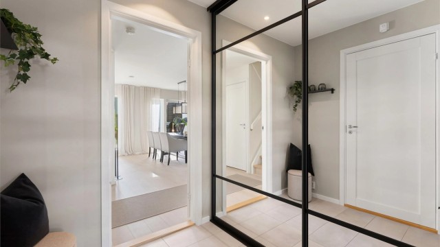 Romslig skyvedørsgarderobe med speilfronter i entréen.