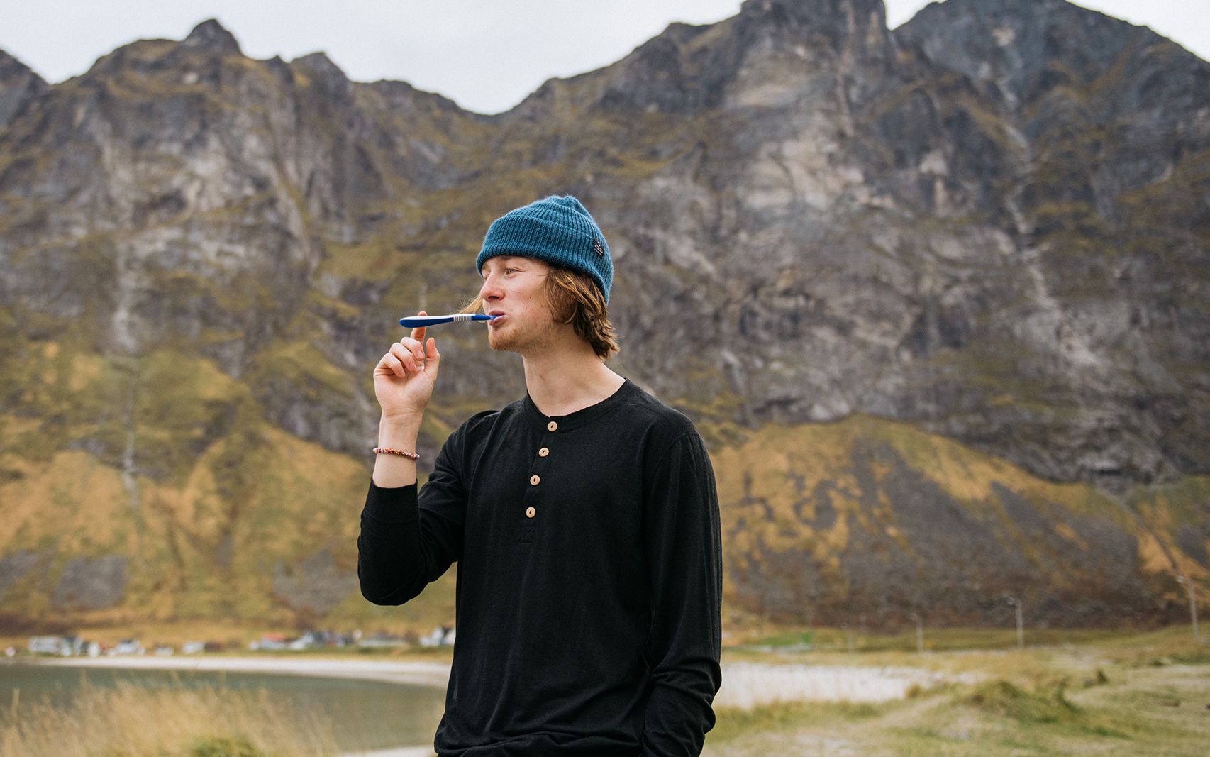 Man standing outside brushing his teeth