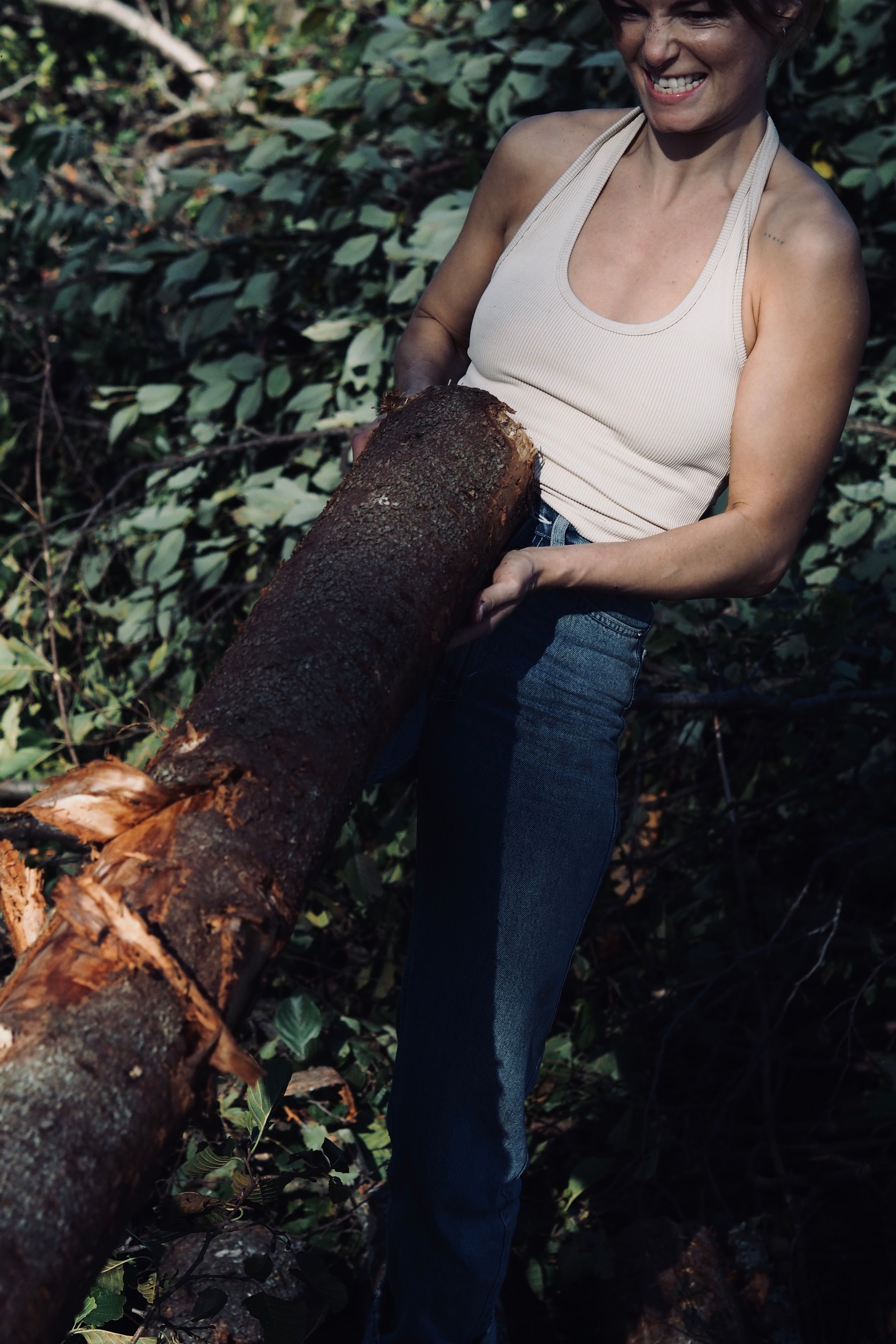 Photo of ambassador Ida Frisch lifting a wooden log.