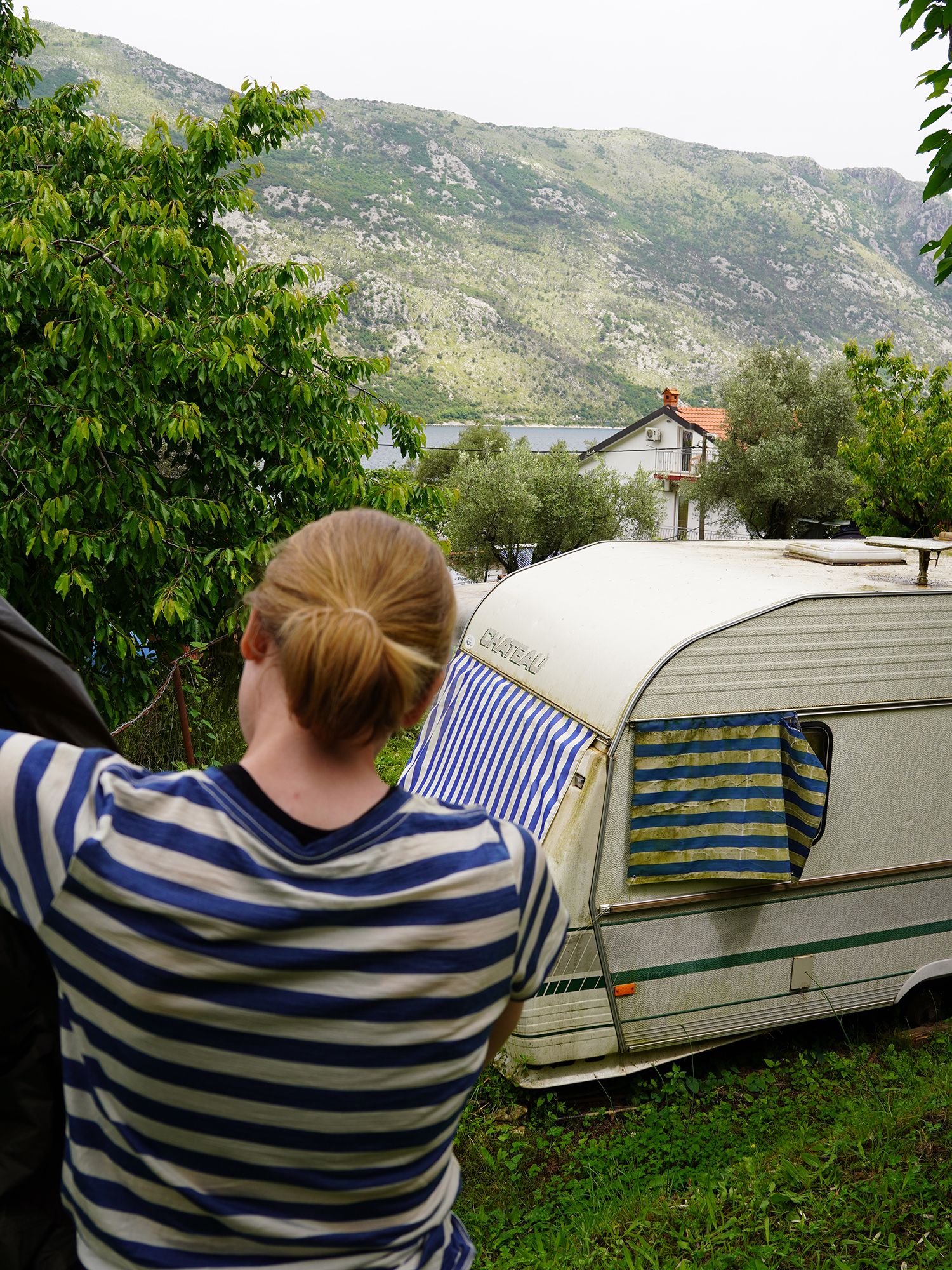 dame setter opp teltet på en campingplass. T-skjorte matcher de gamle markisene på en campingvogn