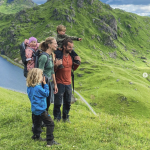 Bilde av en familie på toppene av et fjell.