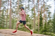 Photo of a man jogging in the white and red striped t-shirt.