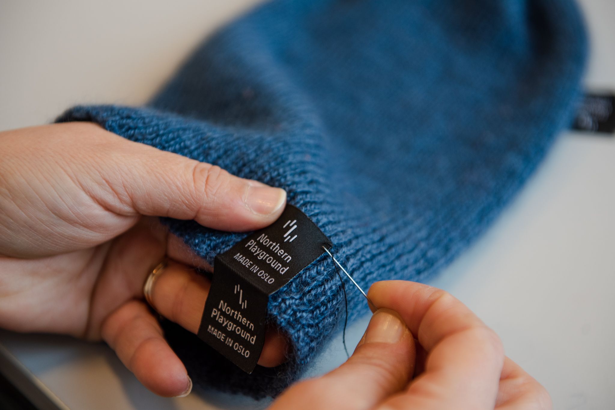 Woman sewing a blue hat