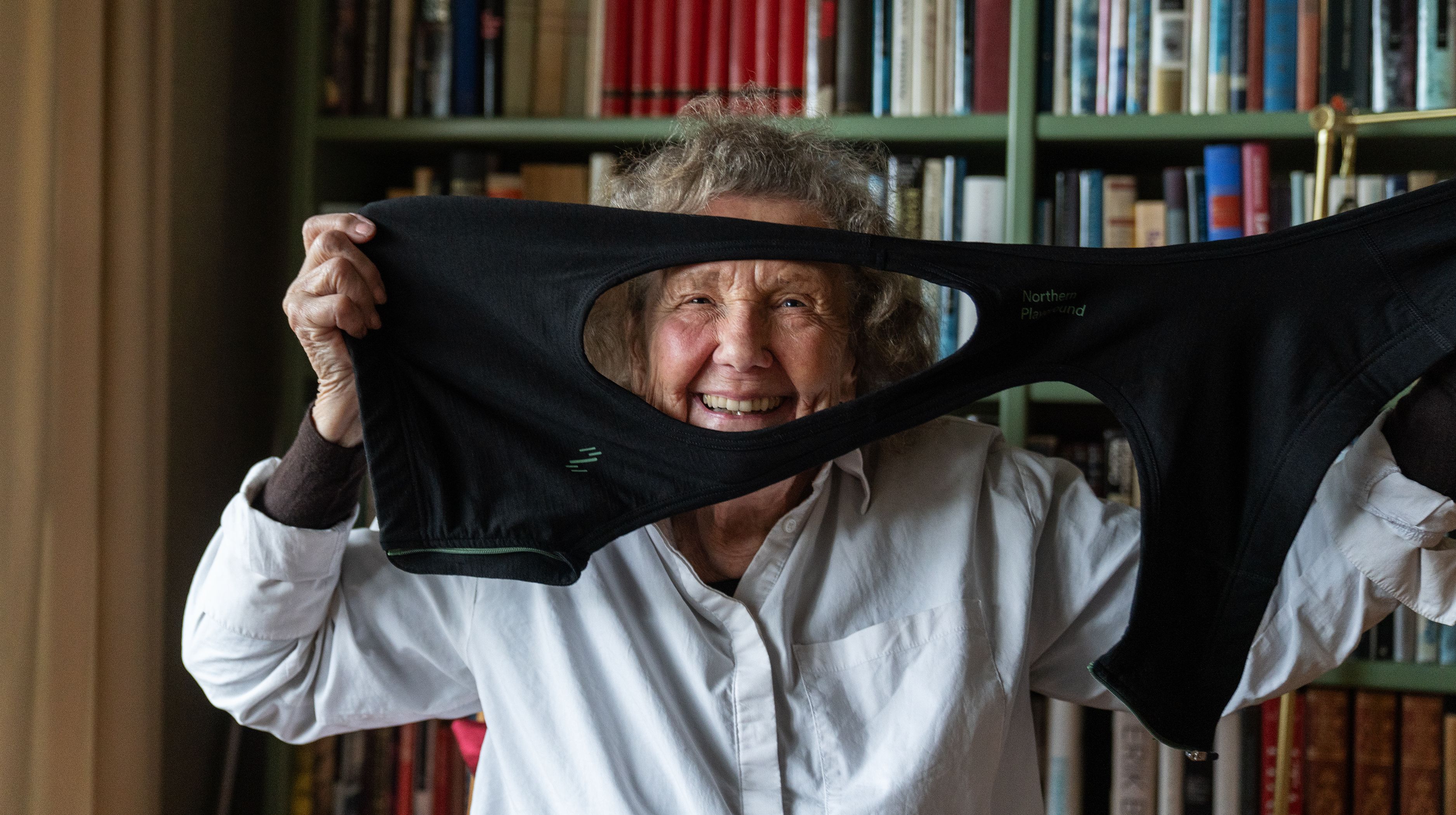 Old woman looking through a hole from her bra