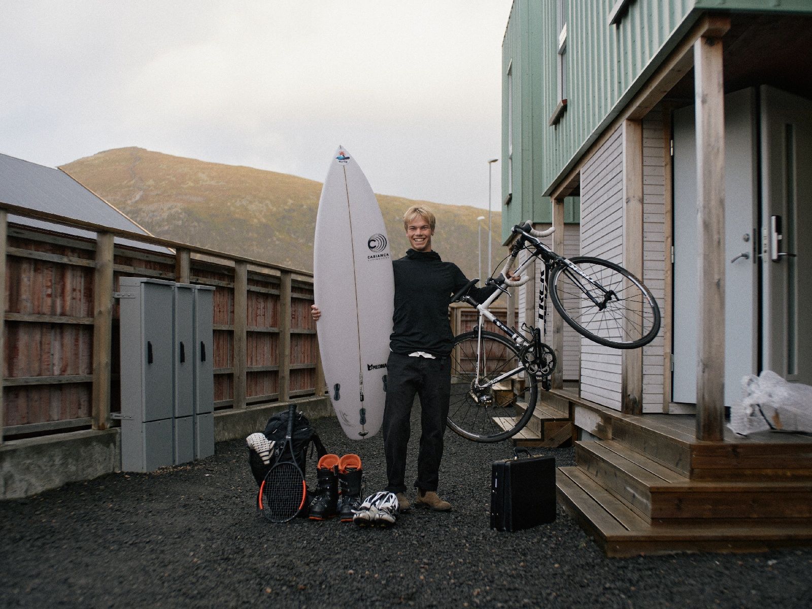 Magnus som holder i et surfebrett og en sykkel