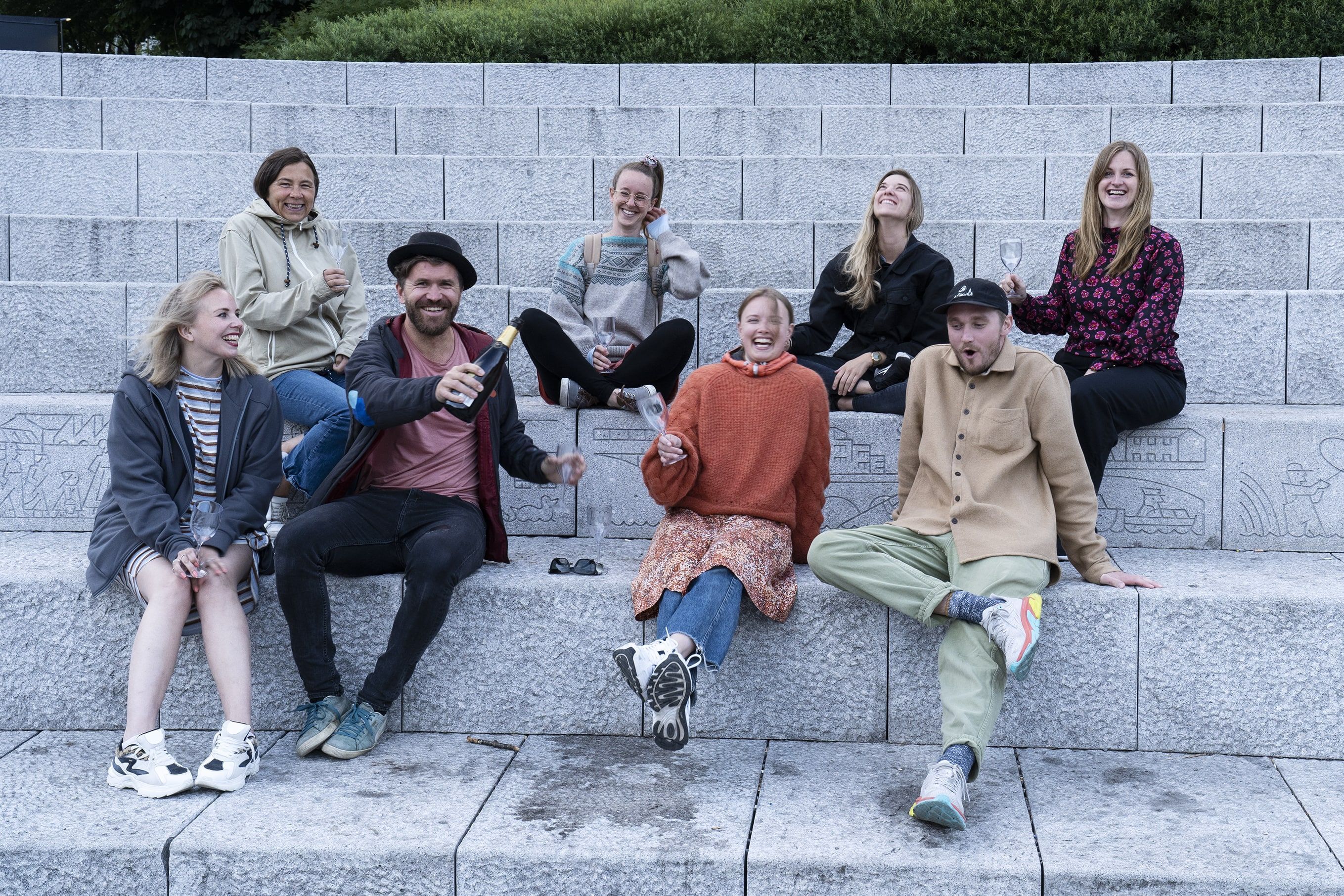 Photo of the NP team sitting on a staircase and drinking champagne.