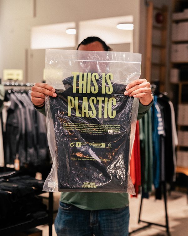 Photo of Adrian holding up the plastic packaging for the products.