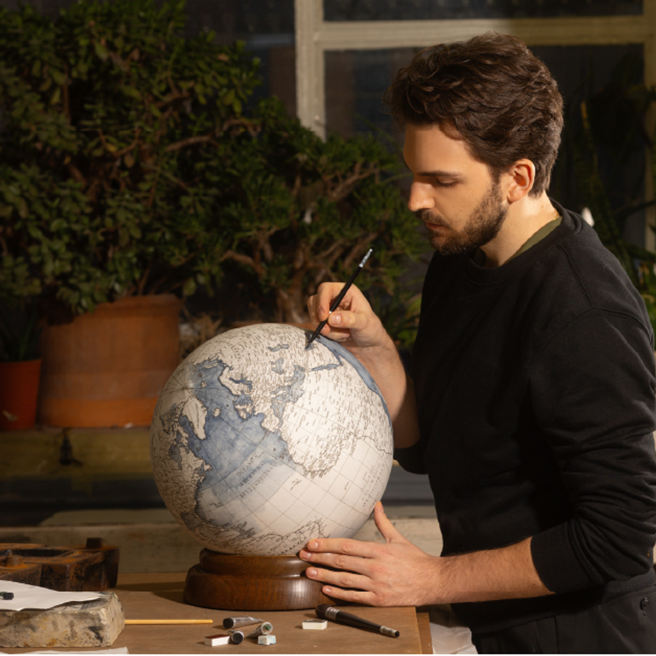 Leonardo Frigo painting and handmade globe in his studio in London