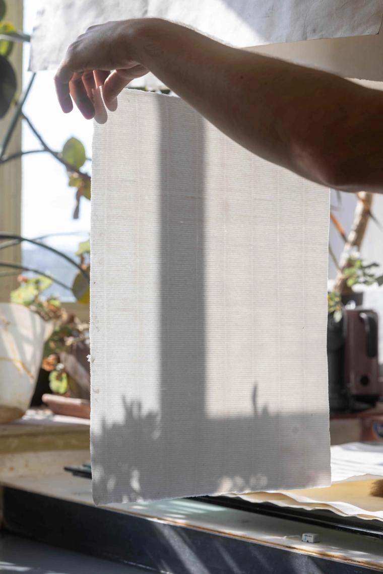 A hand holding a piece of original Fabriano's paper