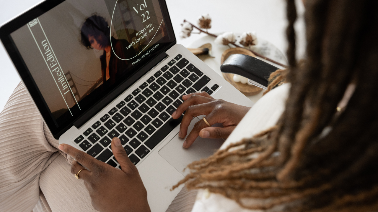 Person working on laptop creating design in canva