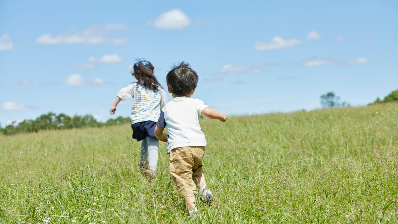 kids running in green field