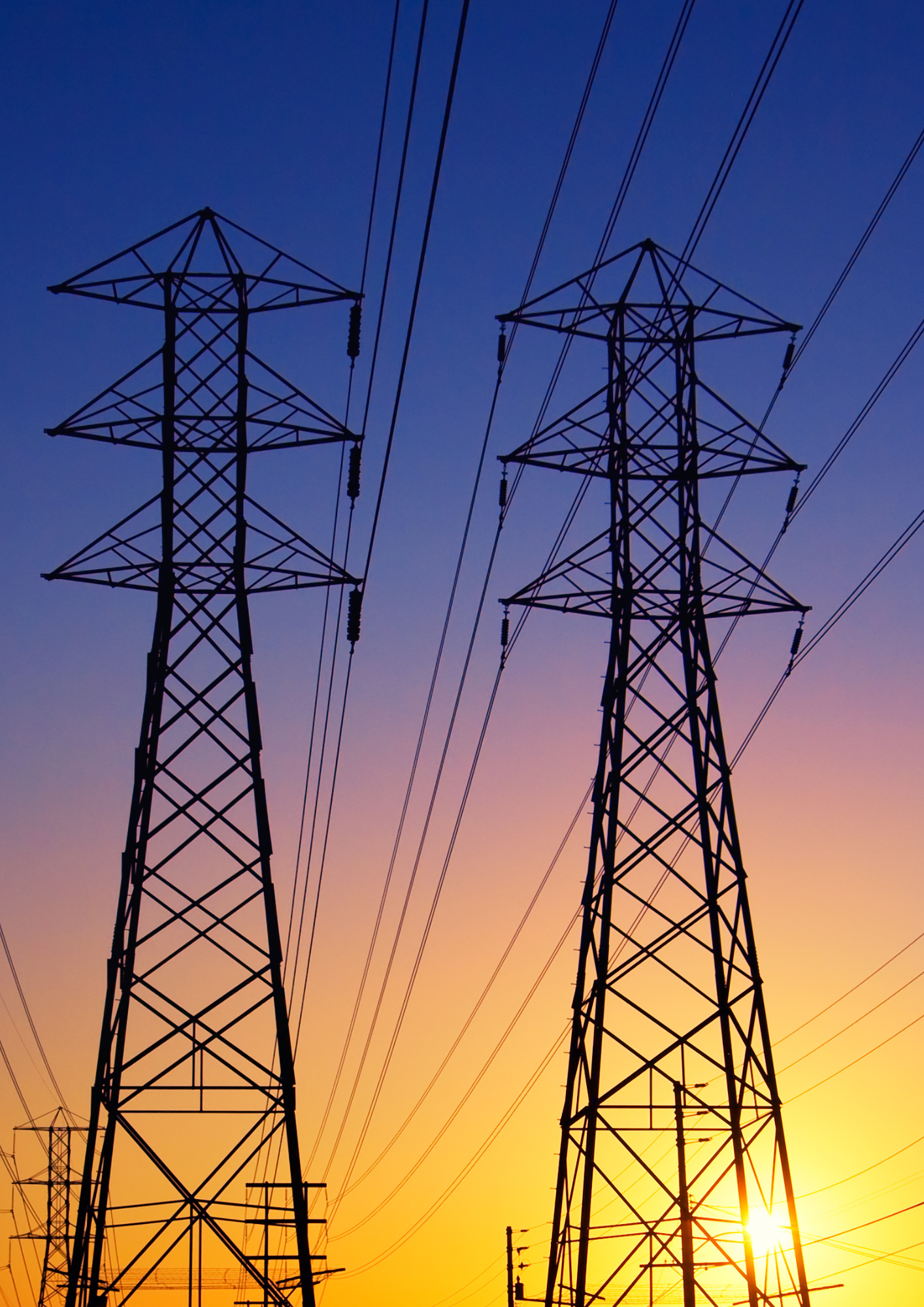 High-voltage transmission towers at sunset.