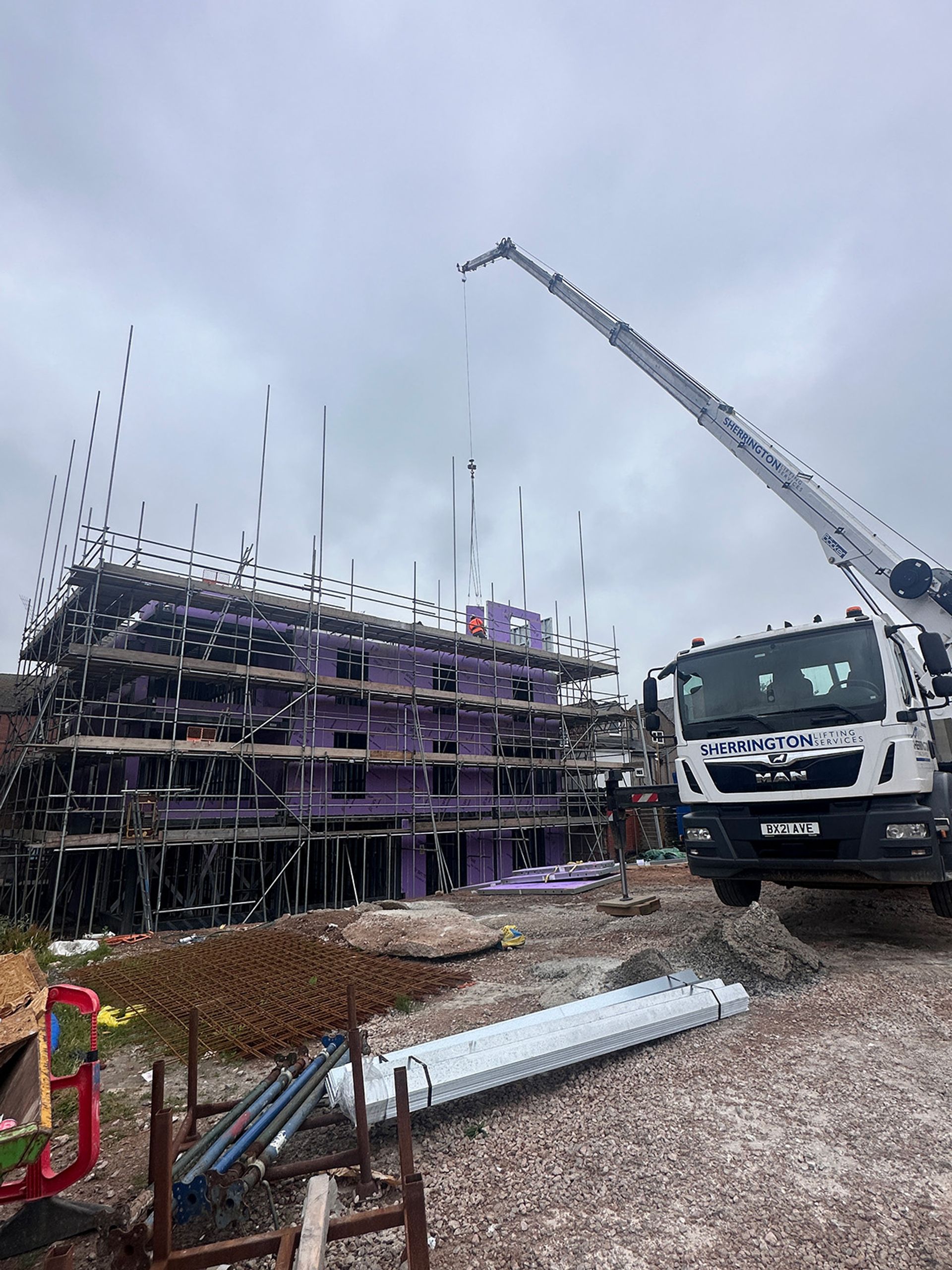 The crane reaching the upper floor as the frame nears full height.