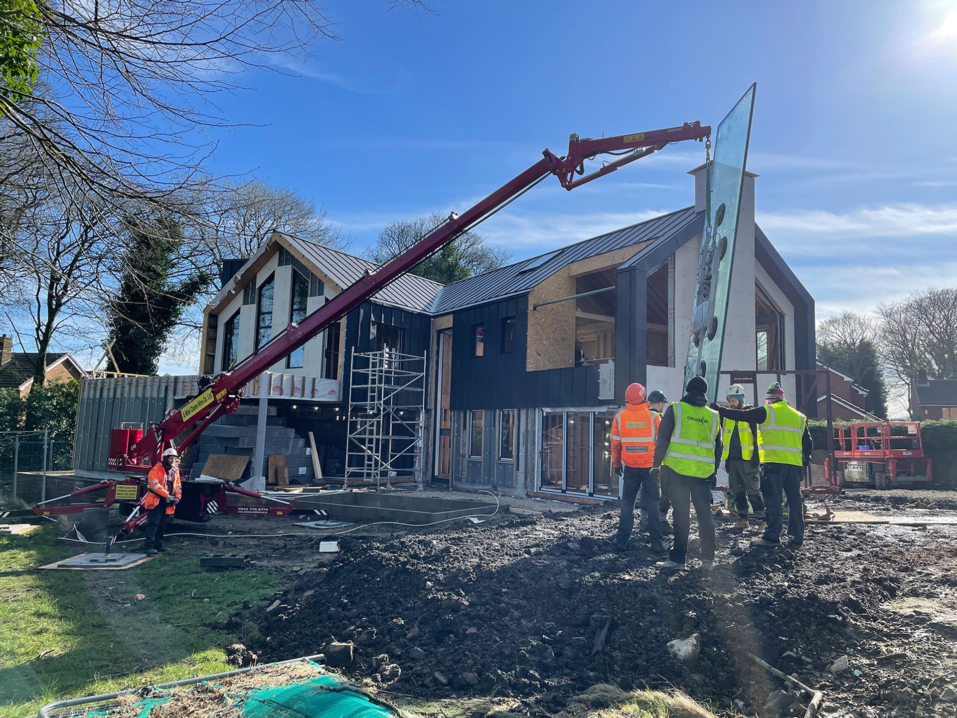 Large format glazing being lifted into the completed frame.