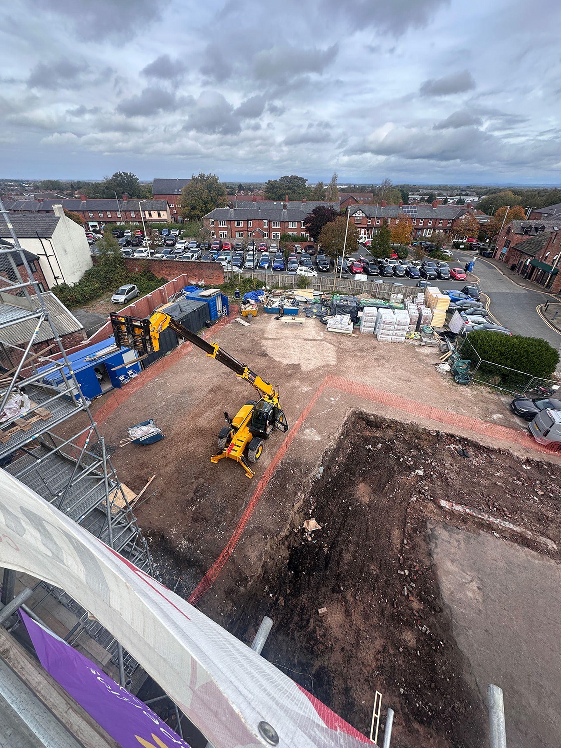 Looking down from the scaffold across the site compound and car park.