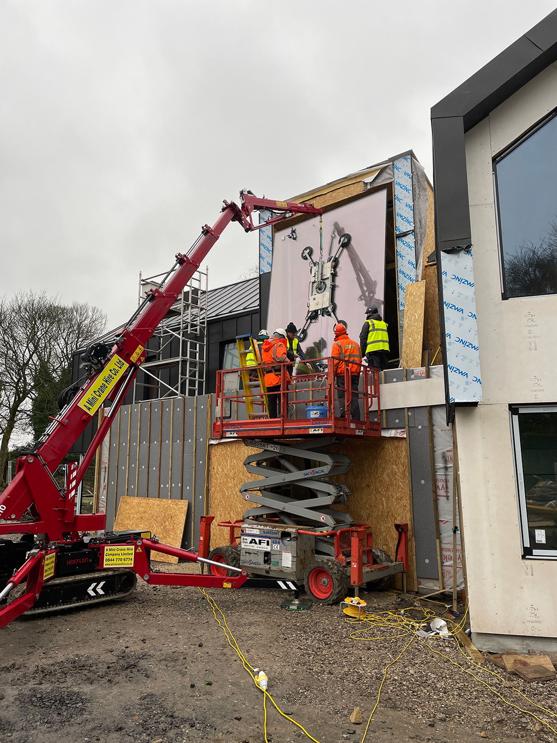 Two of the team guiding a glass panel into its opening.