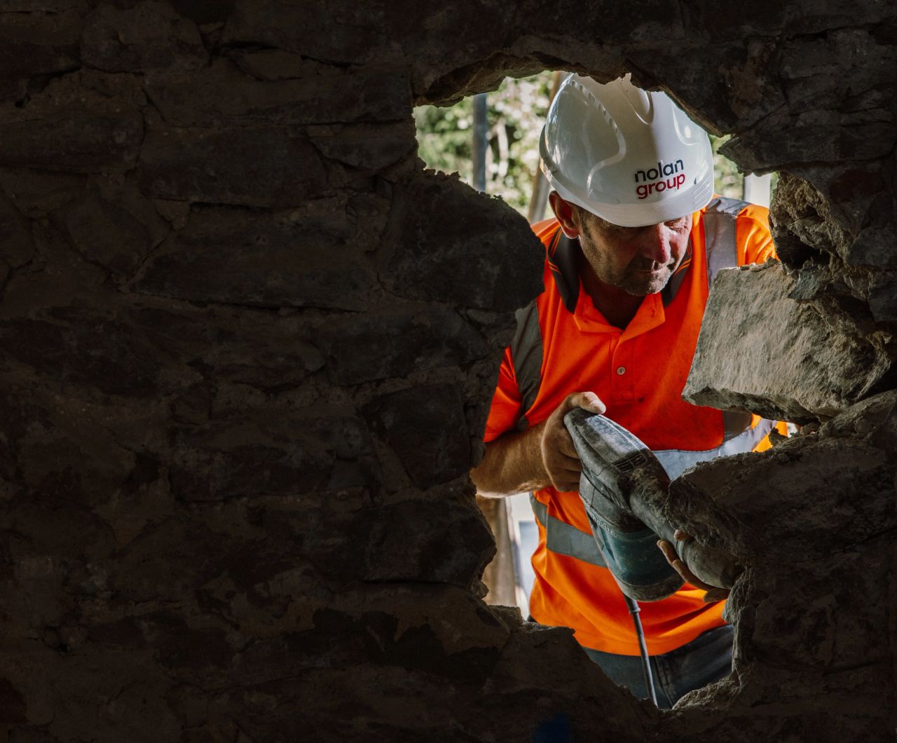 A tradesman working with a drill on site.