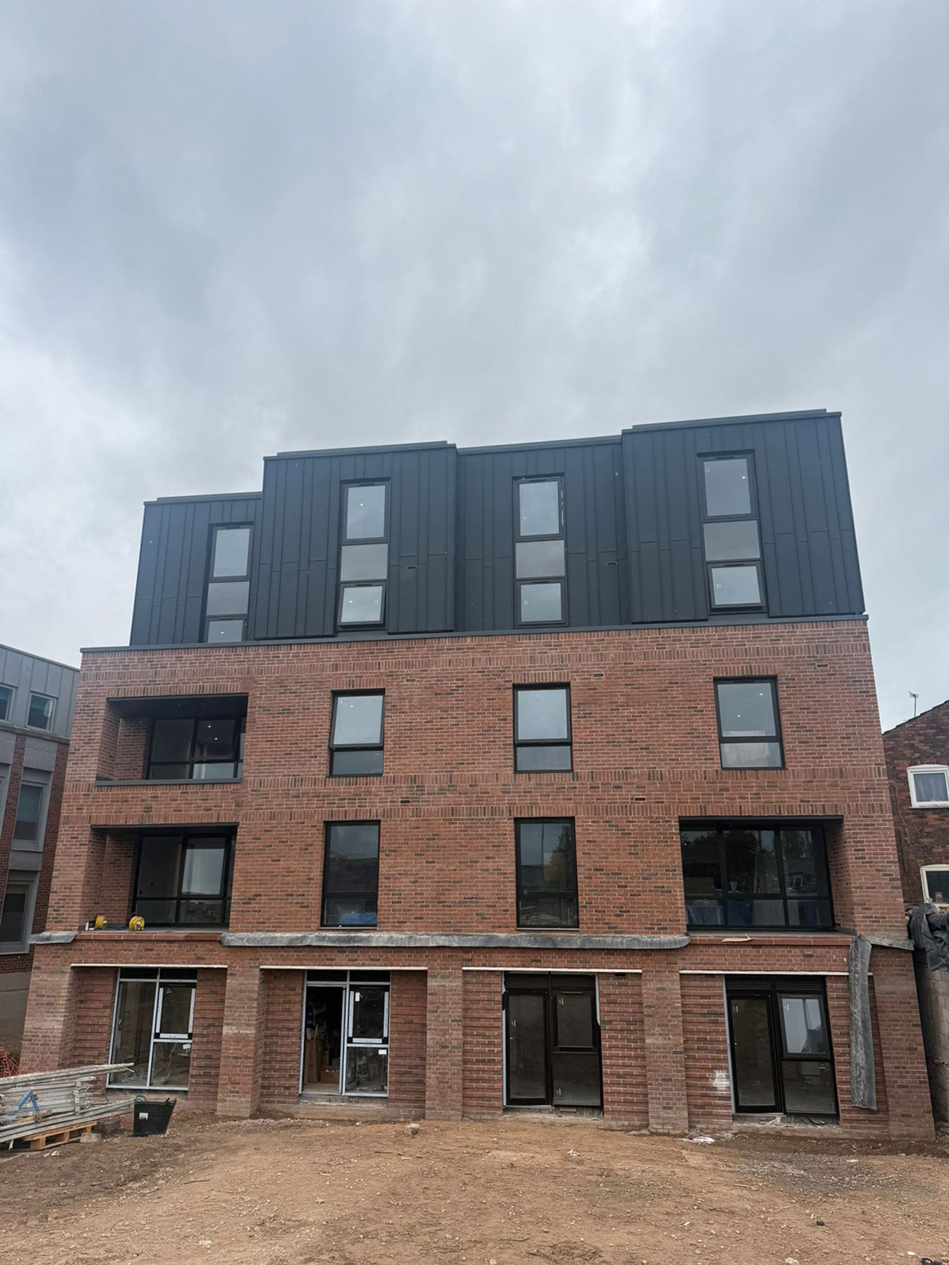 The finished elevation at Church Street, Ormskirk, brick with a dark clad top storey.