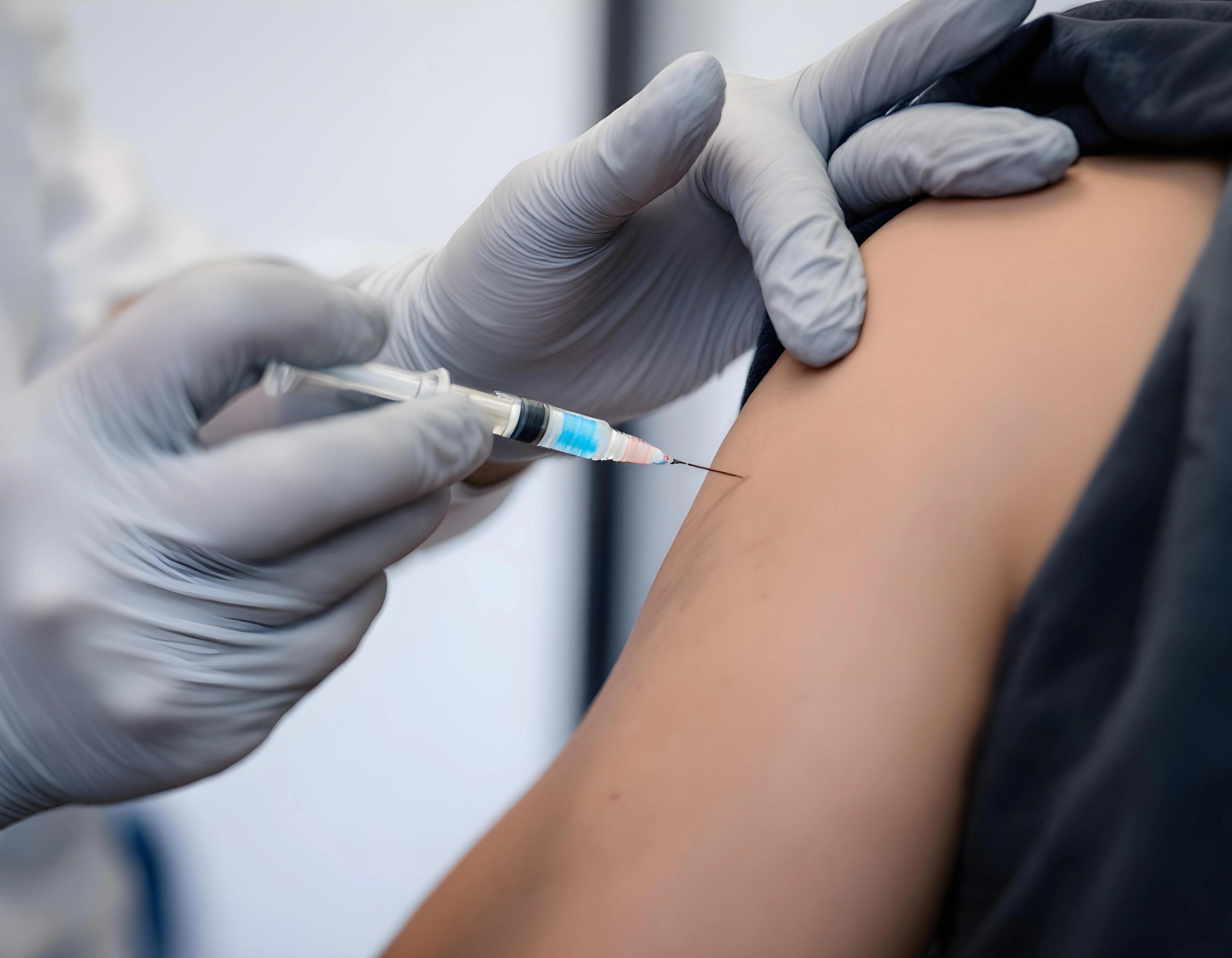 Cover image for the white paper "Encouraging COVID-19 Vaccination: Using Messages to Increase Vaccine Uptake in Saudi Arabia." A healthcare professional administers a COVID-19 vaccine, representing immunization, preventive healthcare, and public health initiatives.