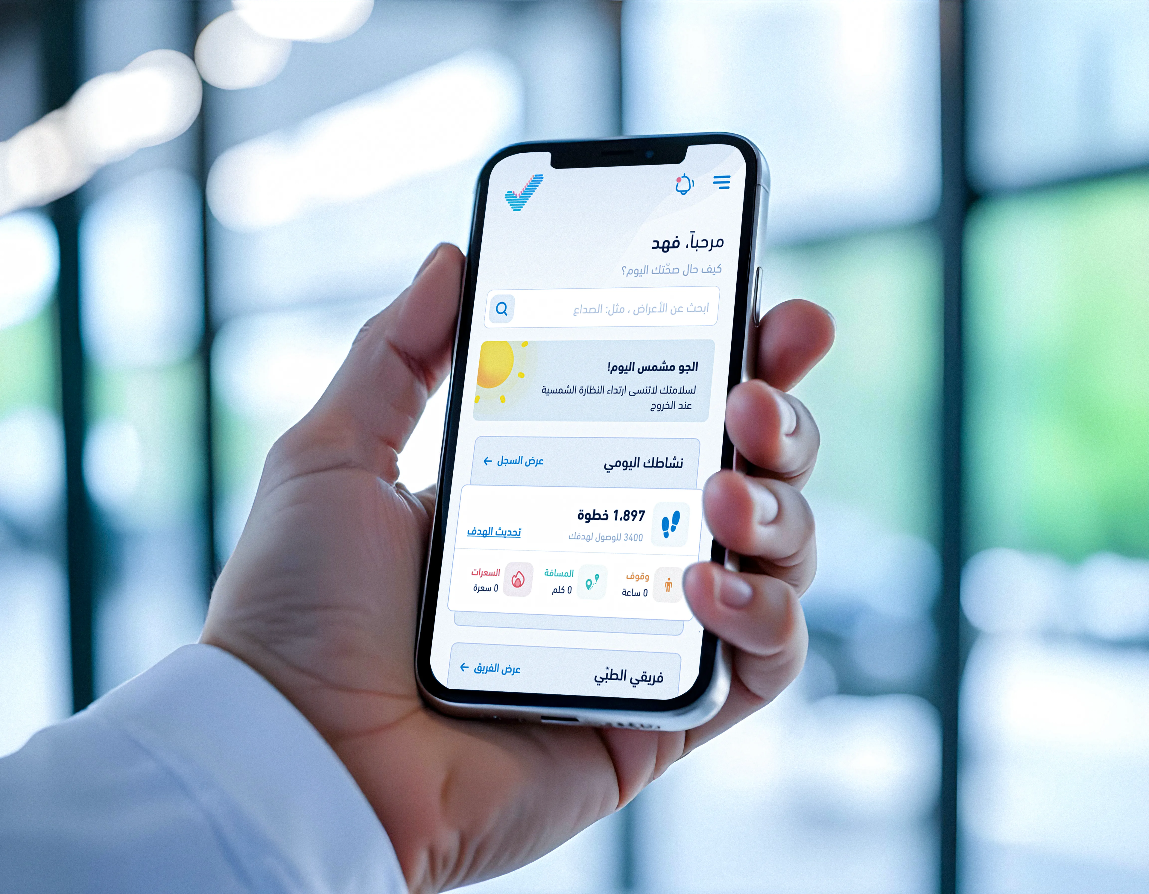 Hand holding a smartphone displaying the Sehhaty app in Arabic with activity tracking, daily steps, and health insights, representing a digital platform for personal health management.