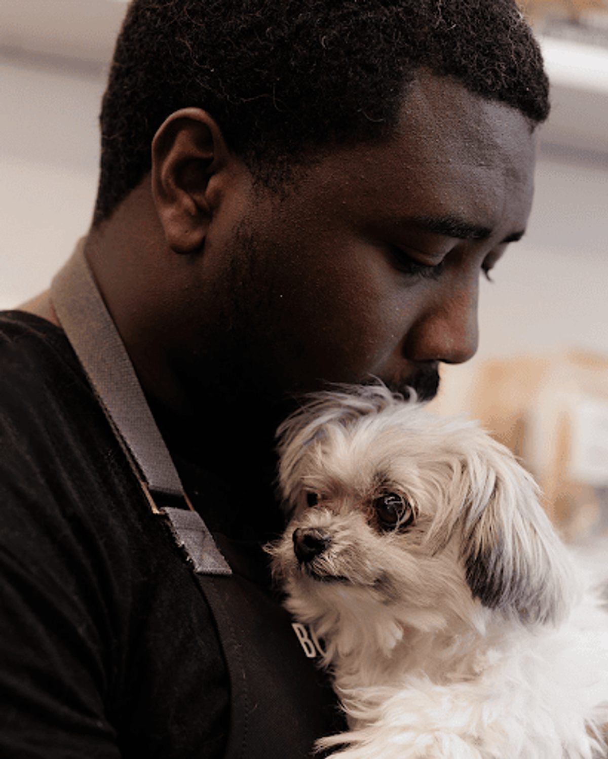 Man holding his small dog in a loving way