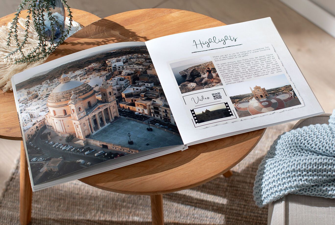 An open photo album on a wooden table displays an aerial photo of a town with a domed church on the left page, and a 'Highlights' spread with travel photos, text, and a QR code on the right.