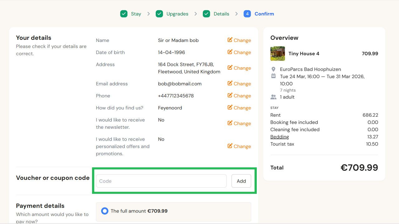 Booking details page showing personal information, a reservation overview for Tiny House 4 totaling €709.99, and a highlighted voucher code input field.