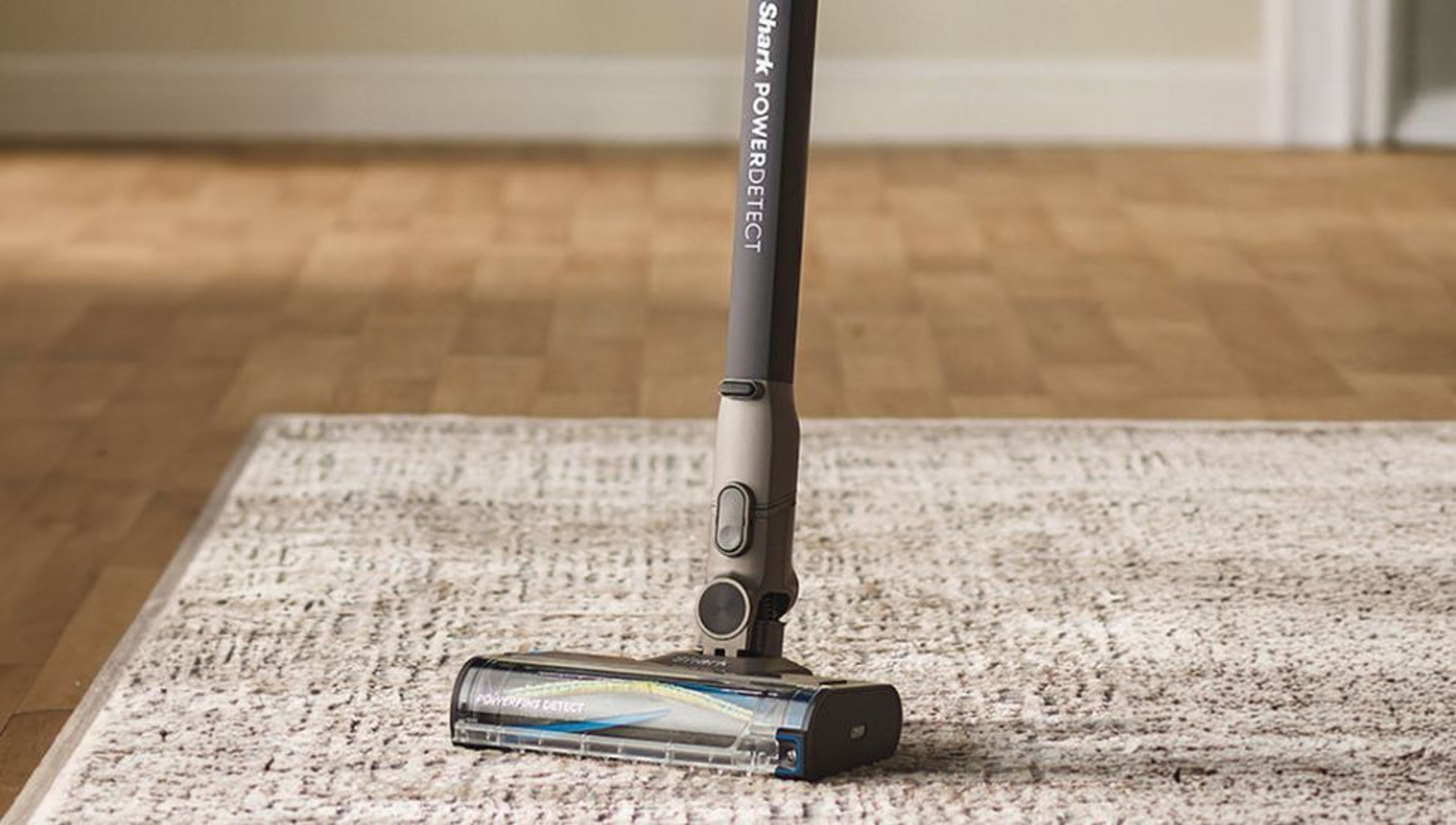 A Shark PowerDetect vacuum cleaner on a patterned rug.