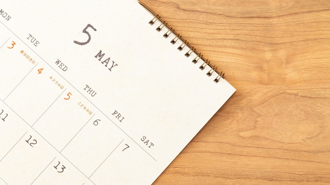 Desk calendar displaying May on a wooden surface.