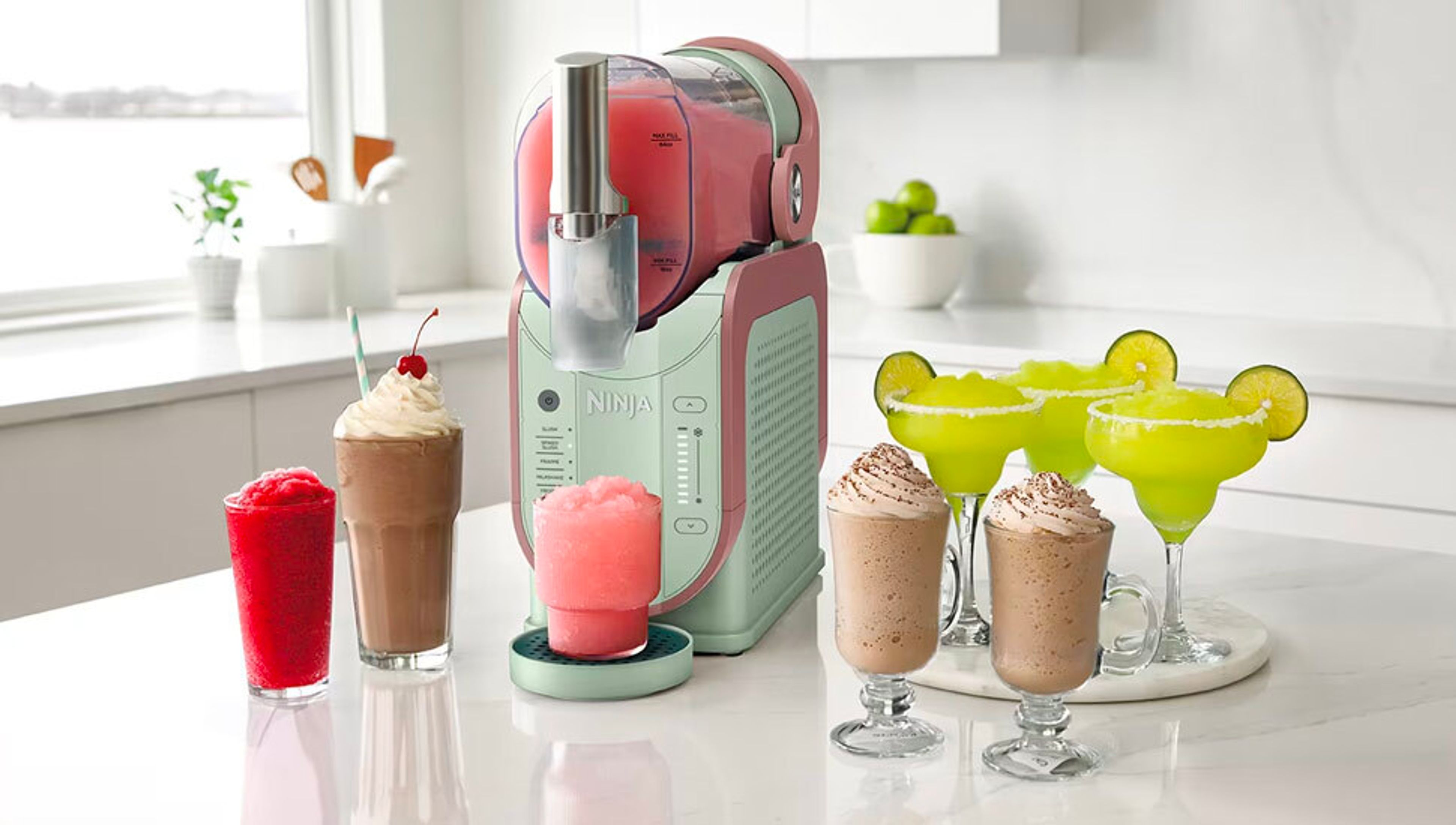 A pink and green Ninja Creami machine on a counter surrounded by various frozen drinks including slushies, milkshakes, margaritas, and frappes.