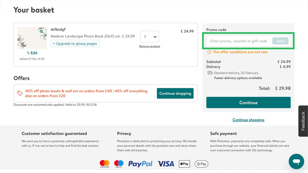 An e-commerce basket page with a photo book item, offers, and a highlighted promo code input field.