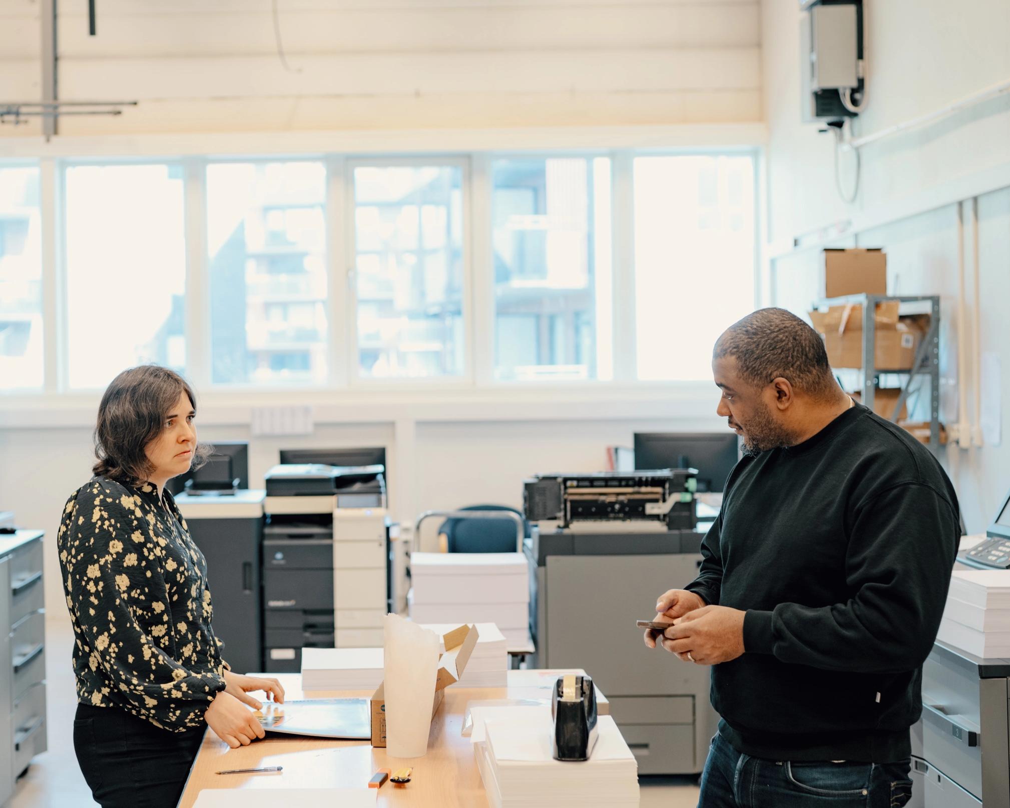 Spir Grafisk & Print, printavdelingen. To personer snakker sammen.