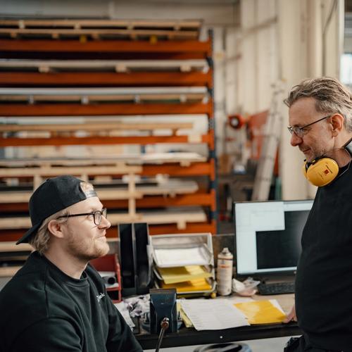 Spir Mekanisk. To kolleger har en samtale i verkstedet.
