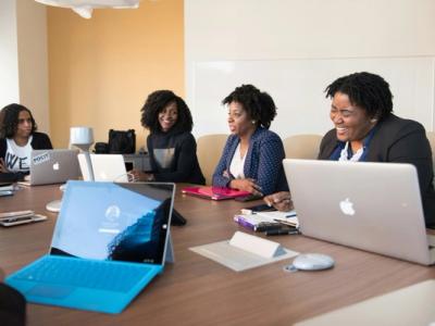 4 black women sitting at a table smiling