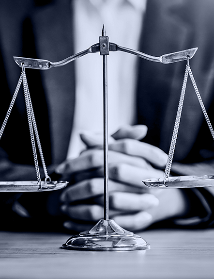 Scales of justice in front of folded hands. Law and justice concept.