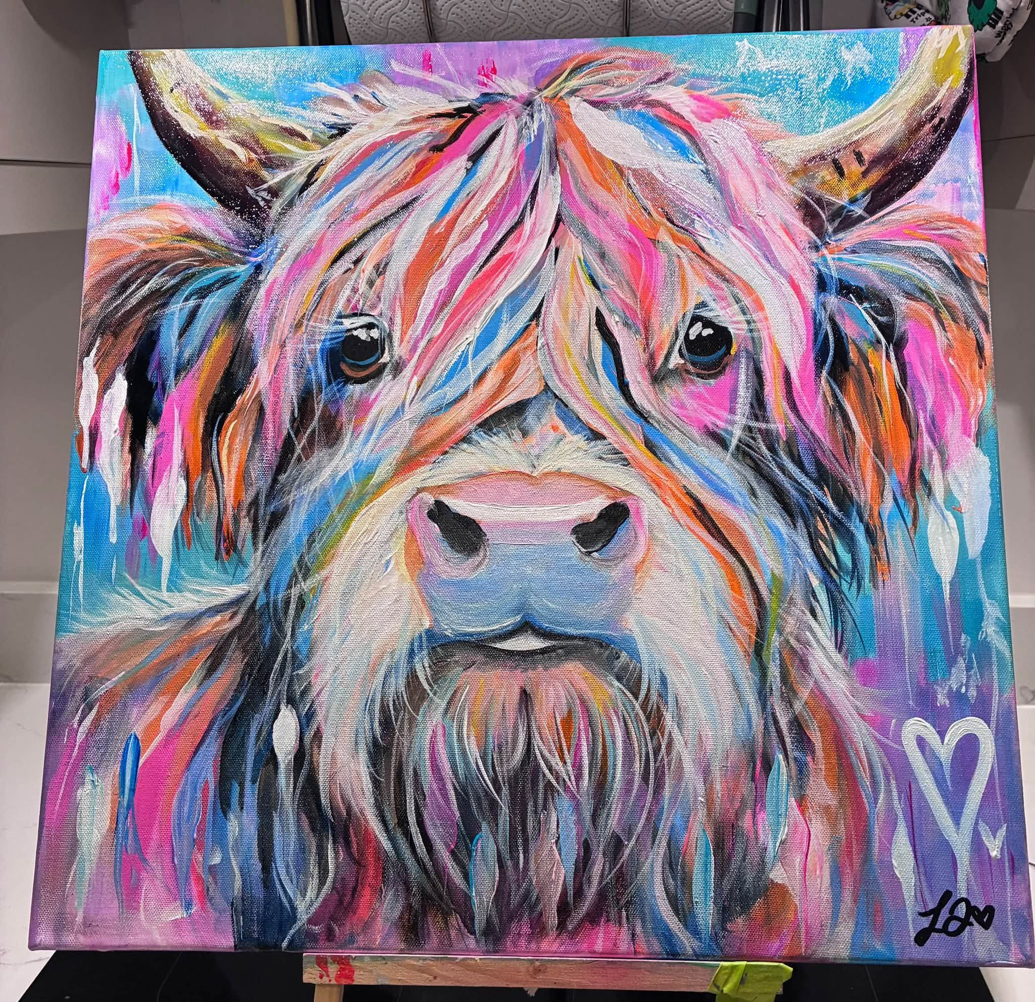 A colourful highland cow painting titled Angus Has Notions, with bright blue, pink and orange tones and wildflowers around the horns
