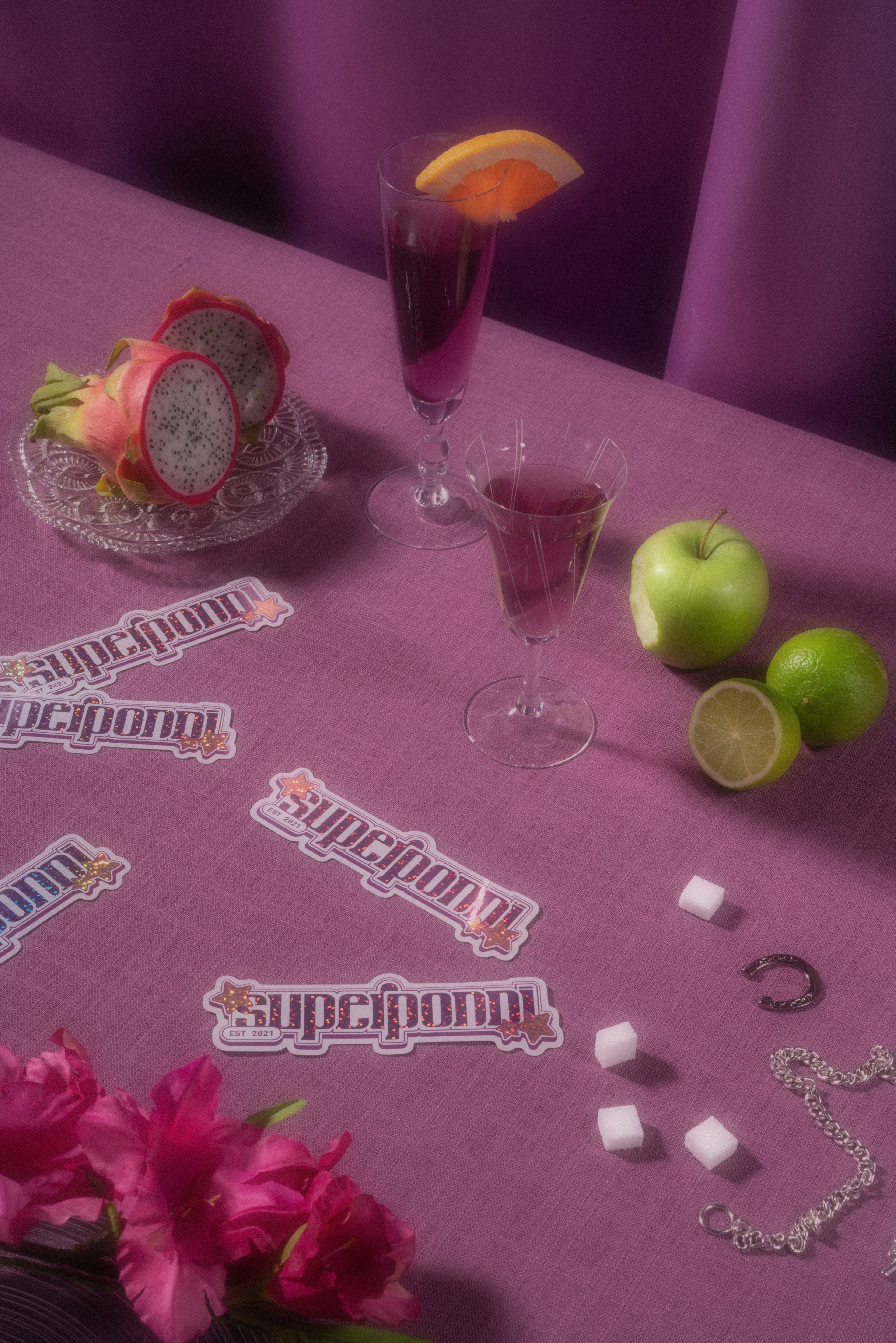 Superponni-klistremerker, epler, lime og drinker på en lilla duk