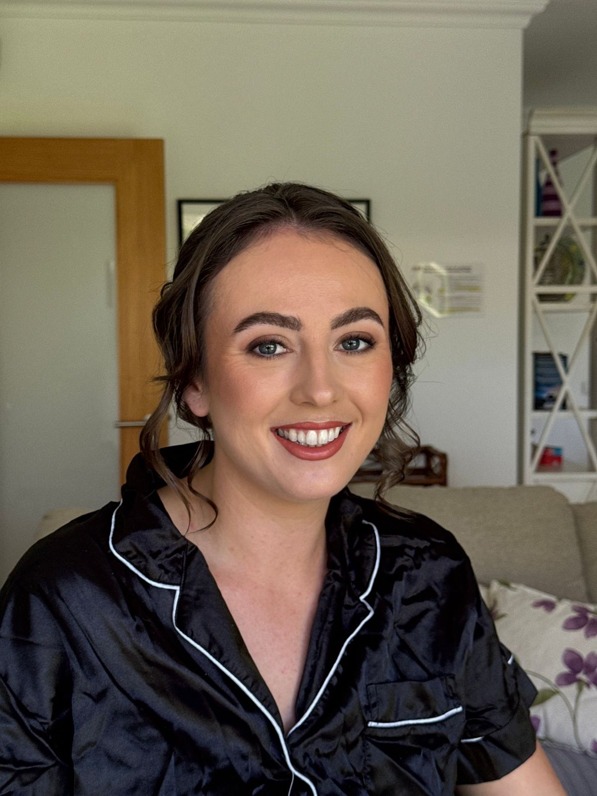 Bride in black satin pyjamas with a soft red lip, photographed before her dress goes on