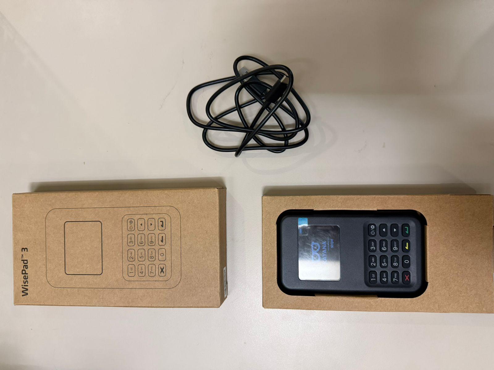 Lector de tarjetas BBPOS WisePad 3 y cable USB-C dispuestos después de desempacar.