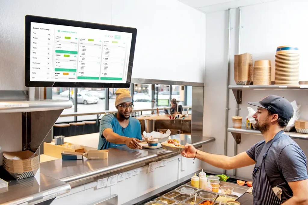 Restaurant kitchen staff using a Kayana KDS to manage active and pending orders