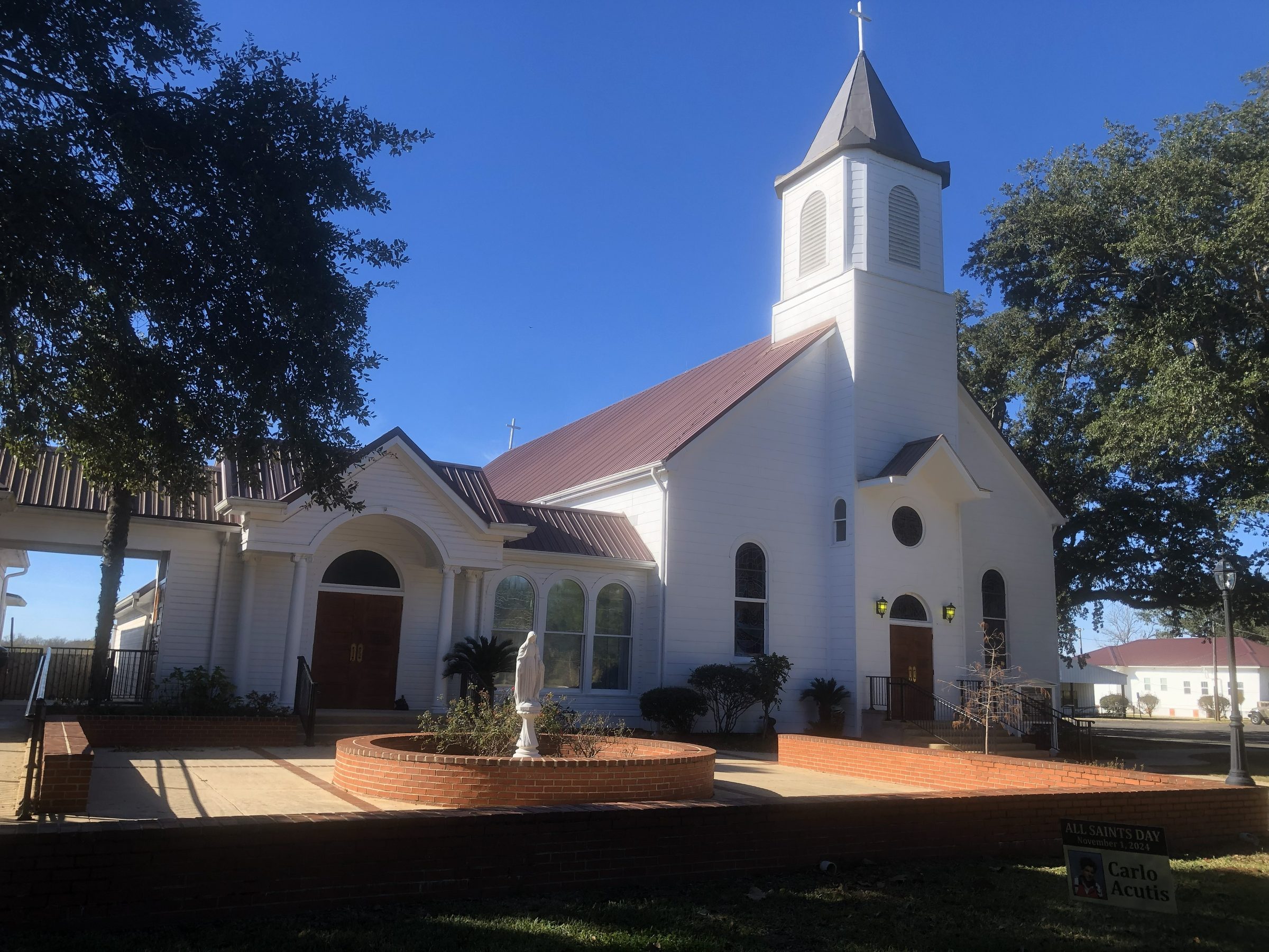 Historic white church with a bell tower and a fountain in the forecourt