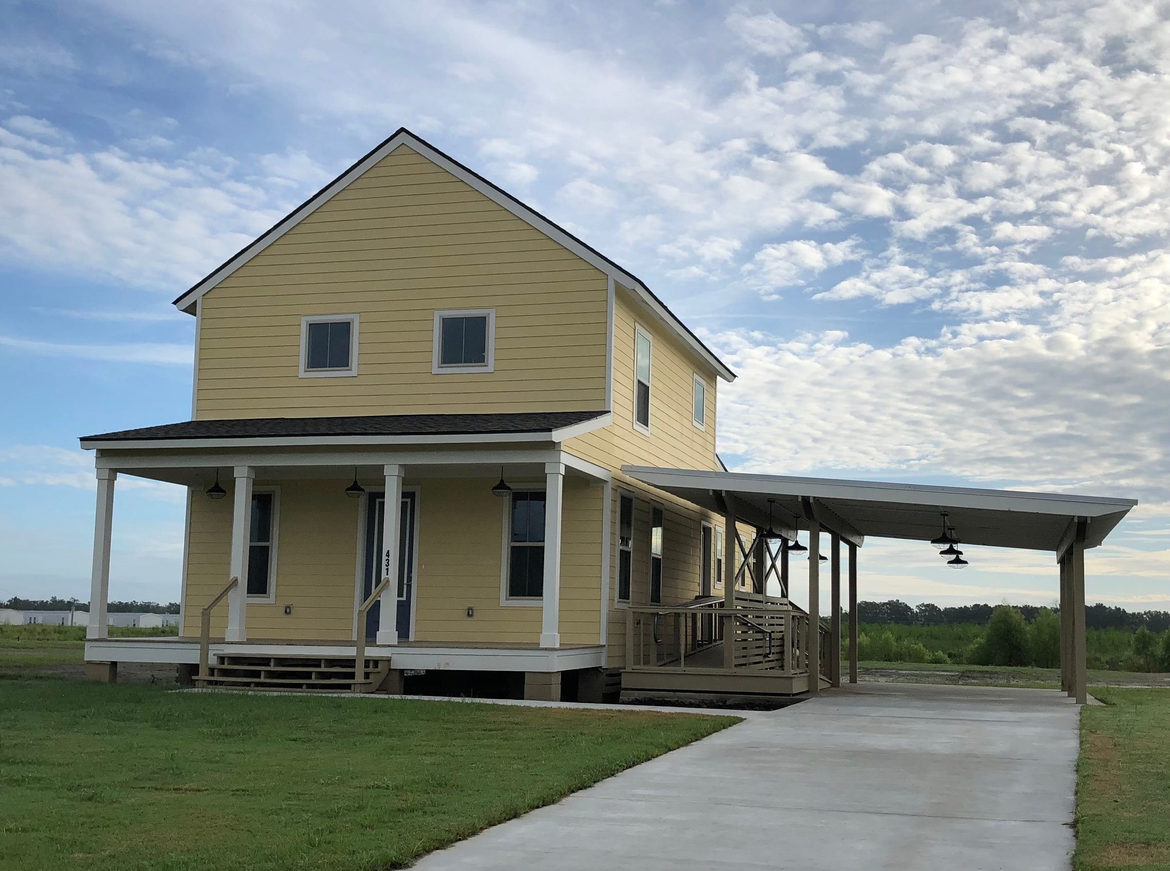 Two-storey yellow house with a wraparound porch