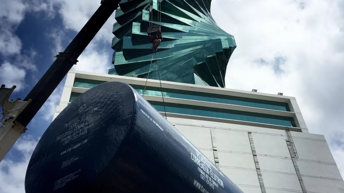 Black underground tank suspended by a crane during an installation in Panama City.