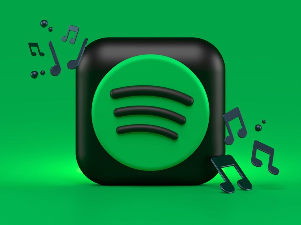 The image features the Spotify logo, prominently displayed against a green background. Surrounding the logo are musical notes, indicating a focus on music and audio streaming. — Credit: Photo by Alexander Shatov on Unsplash